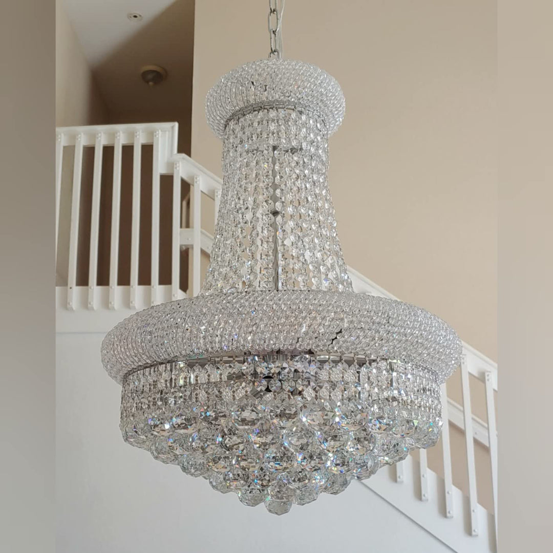 Crystal chandelier hanging in a room with a staircase in the background