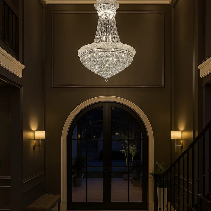 Chandelier hanging in a dimly lit hallway with an archway and staircase.