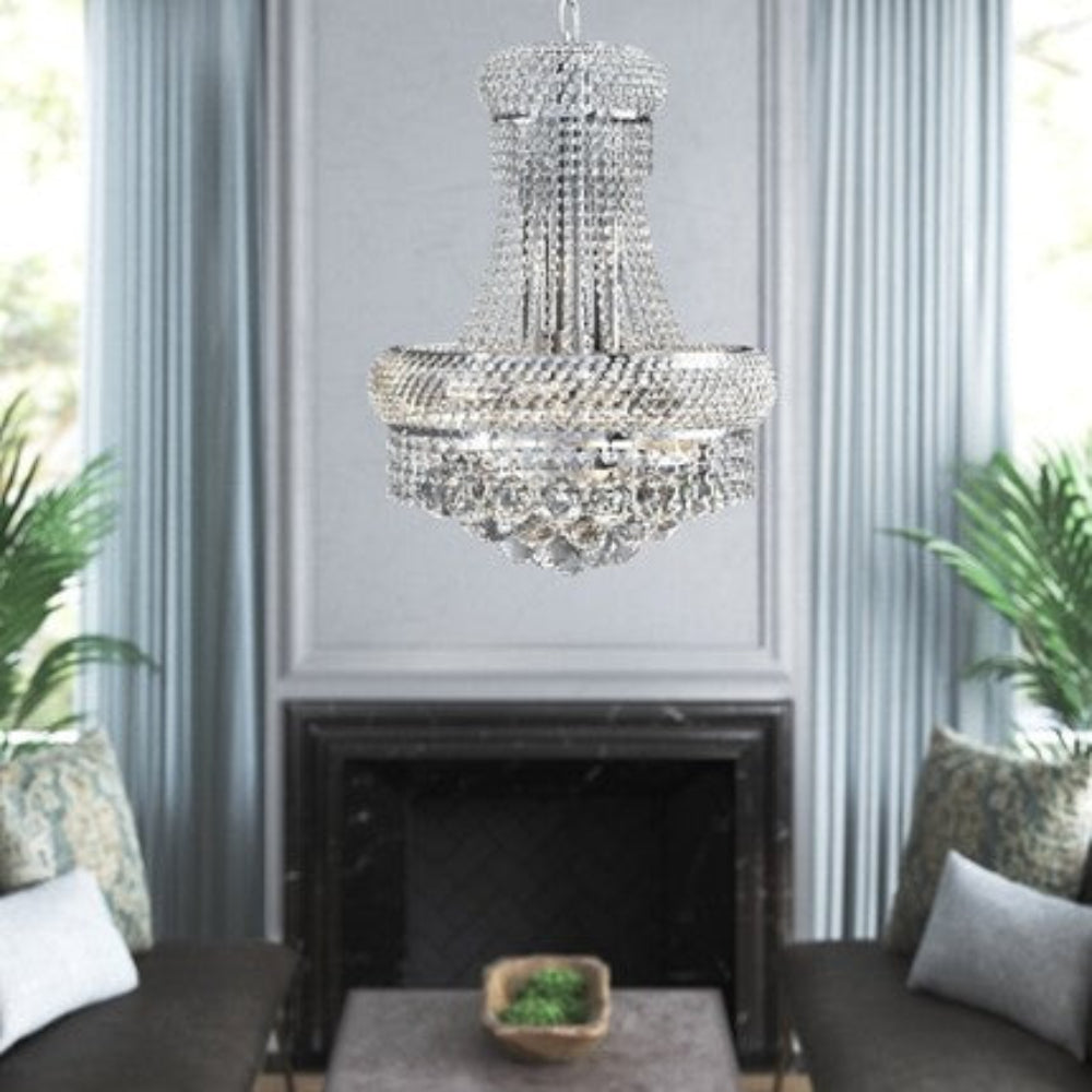 Crystal chandelier hanging above a fireplace with decorative elements.