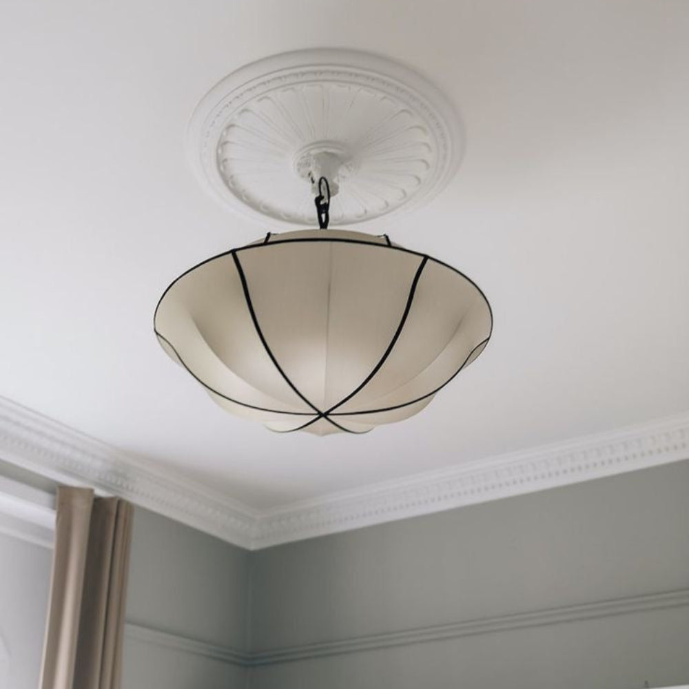 Ceiling light fixture in a room with white walls and a curtain.