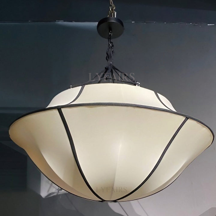 Ceiling light fixture with beige shade and black metal frame on a dark background