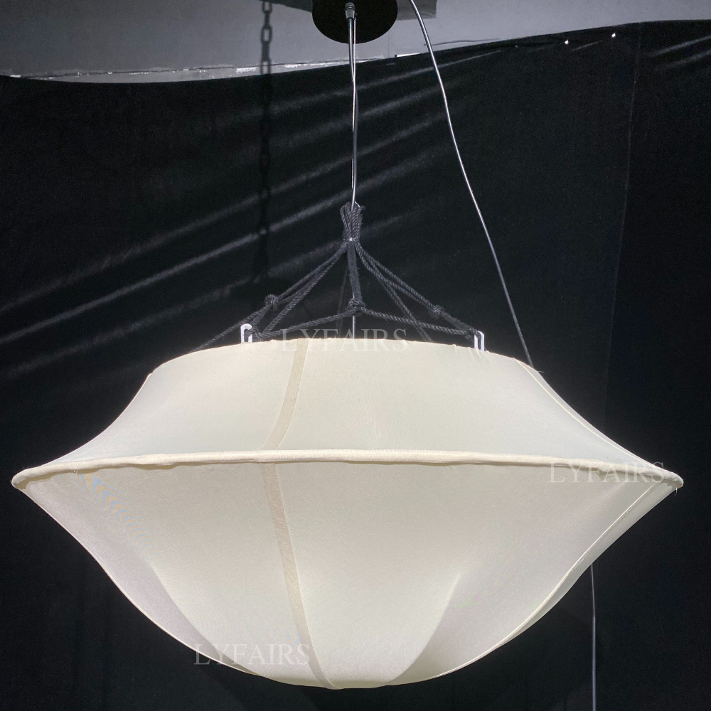 White pendant light hanging against a black background
