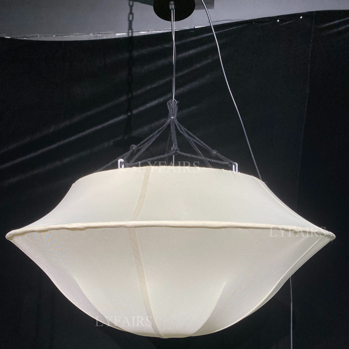 White pendant light hanging against a black background