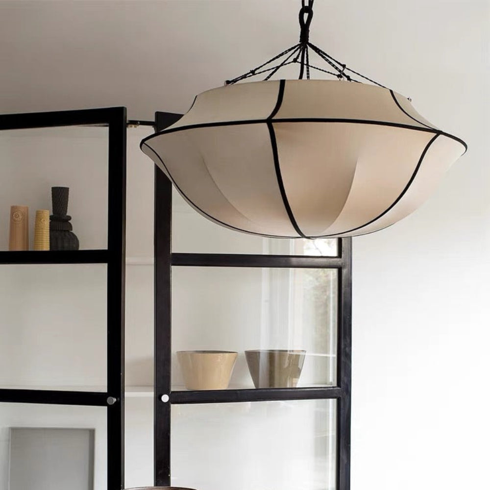 Set of ceramic bowls on a wooden table with a modern pendant light in the background.
