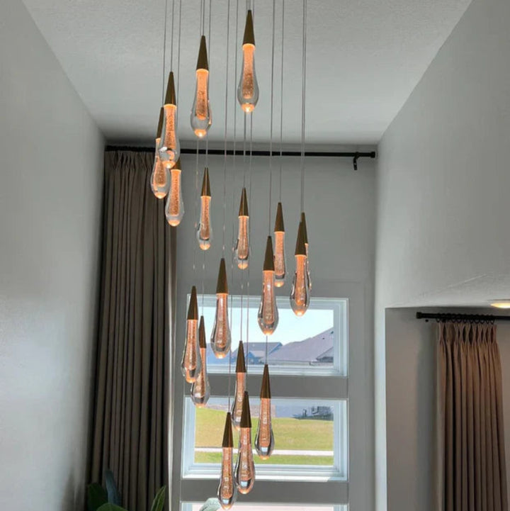 Modern chandelier with hanging light bulbs in a room with large windows.