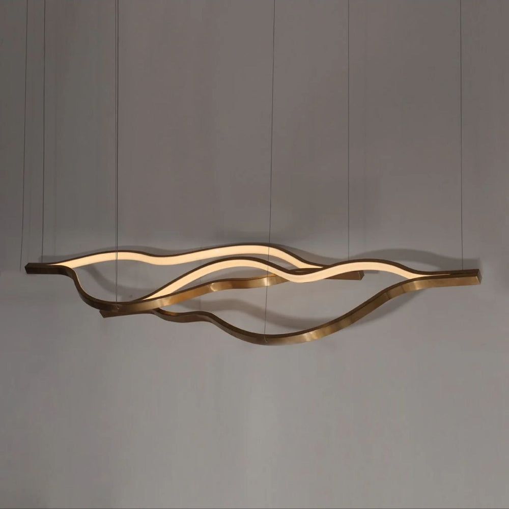 Modern gold pendant light fixture on a gray background