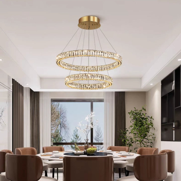Dining room with a modern chandelier, round table, and chairs.