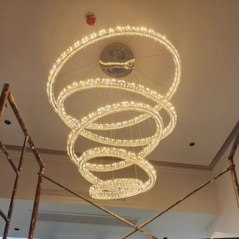 Large spiral chandelier in a room with scaffolding and a cityscape view.