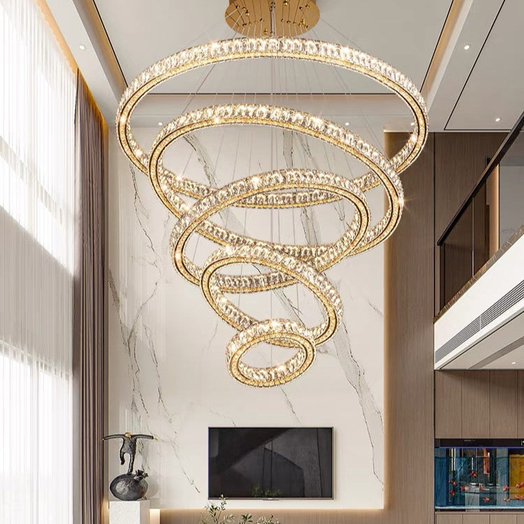 Luxury chandelier in a modern living room setting with marble wall and television.