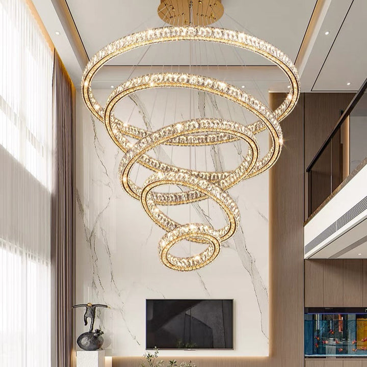 Luxury chandelier in a modern living room setting with marble wall and television.
