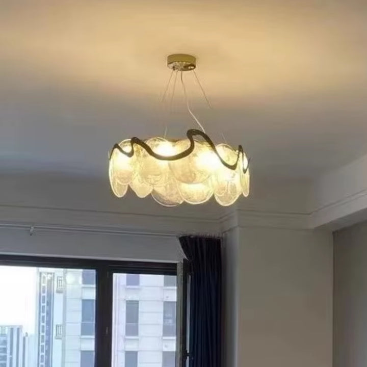 Modern chandelier hanging in a room with a window in the background