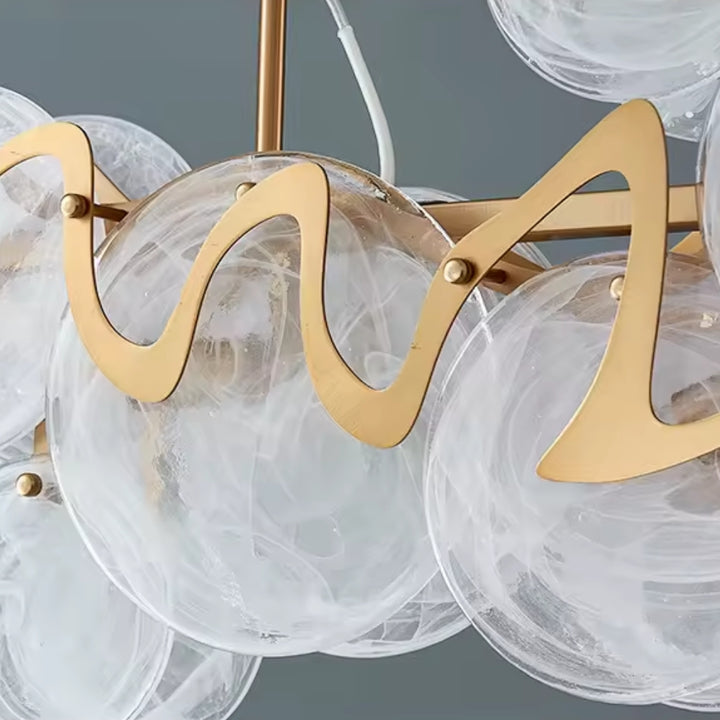 Chandelier with gold fixtures and clear glass shades on a gray background