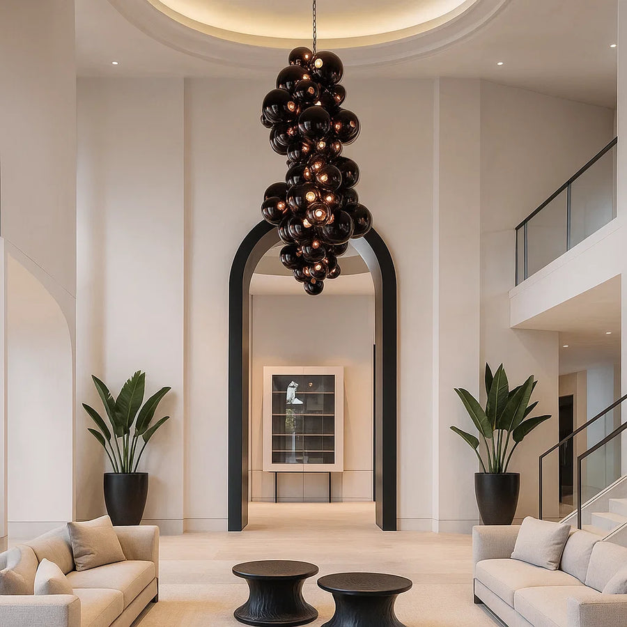 Modern interior with a chandelier, potted plants, and a staircase.