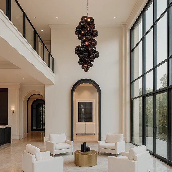 Modern living room with white furniture, a gold coffee table, and a unique black chandelier.