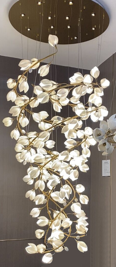 Chandelier with white floral design and gold accents hanging from a ceiling.