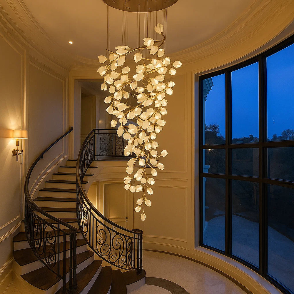Luxurious staircase with a large, intricate chandelier in a well-lit hallway.