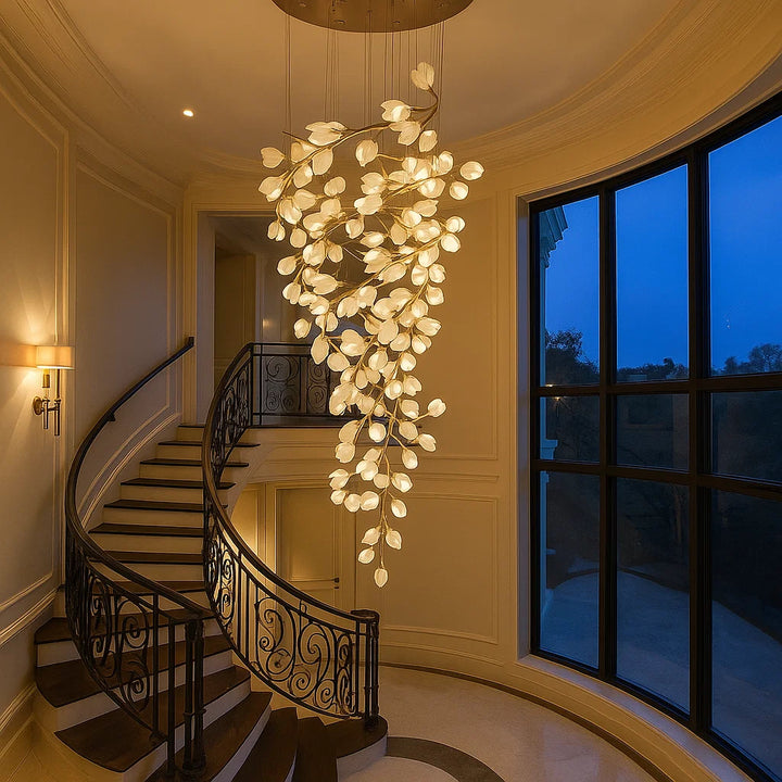 Luxurious staircase with a large, intricate chandelier in a well-lit hallway.