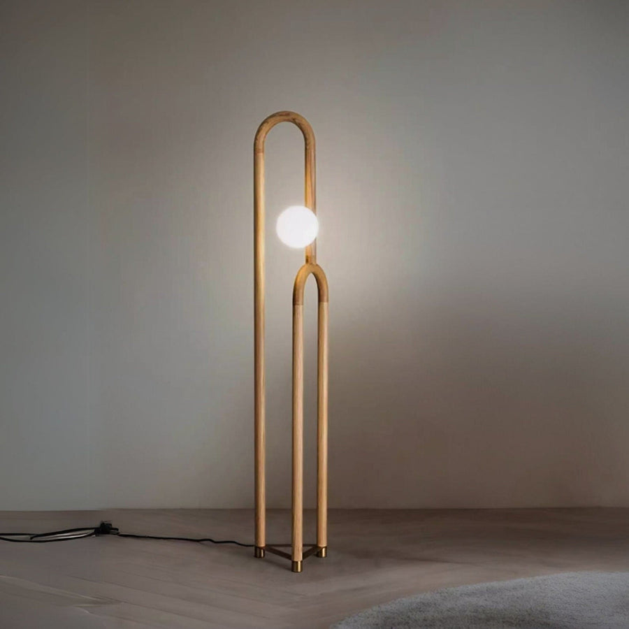 Modern floor lamp with a single bulb on a plain background