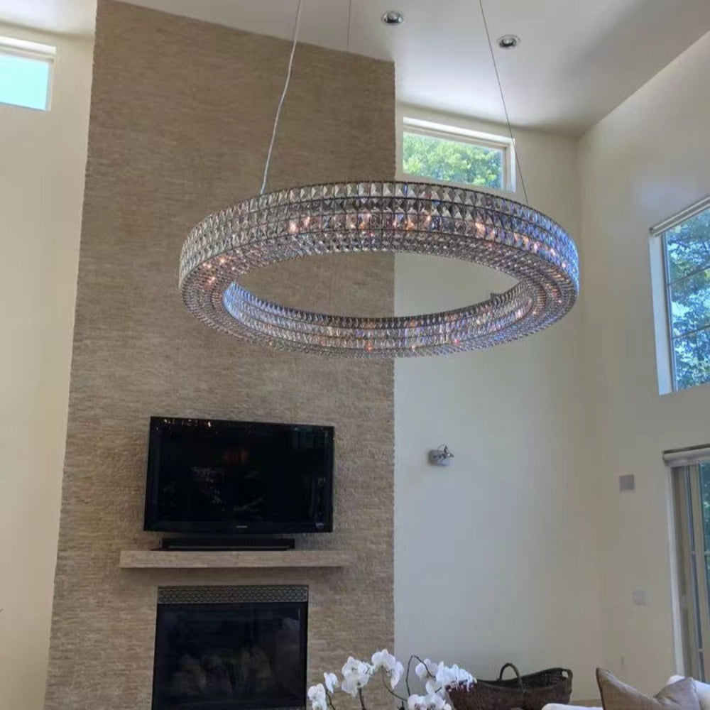 Modern living room with a chandelier, TV, fireplace, and decorative elements.