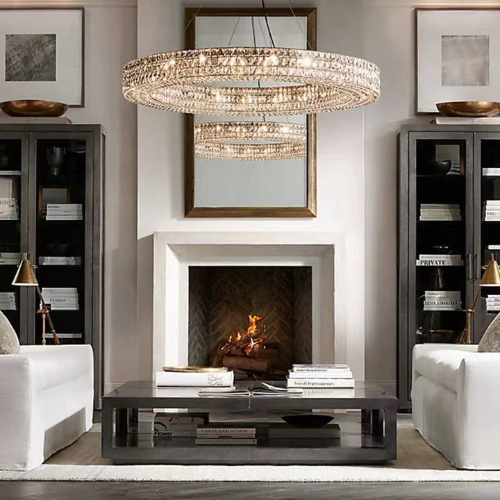 Living room with a chandelier, fireplace, and white furniture.