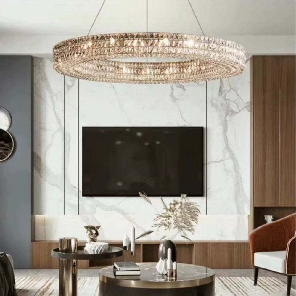 Modern living room with a chandelier, TV, and decorative items.