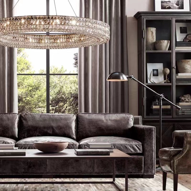 Modern living room with a chandelier, sofa, and bookshelf.