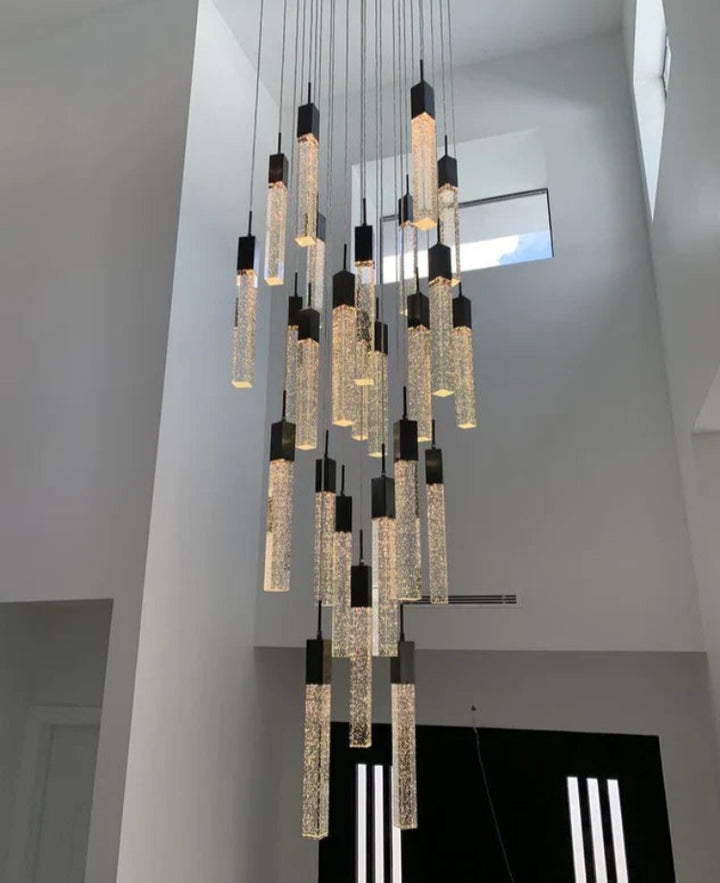 Modern chandelier with multiple hanging lights in a room with high ceilings.