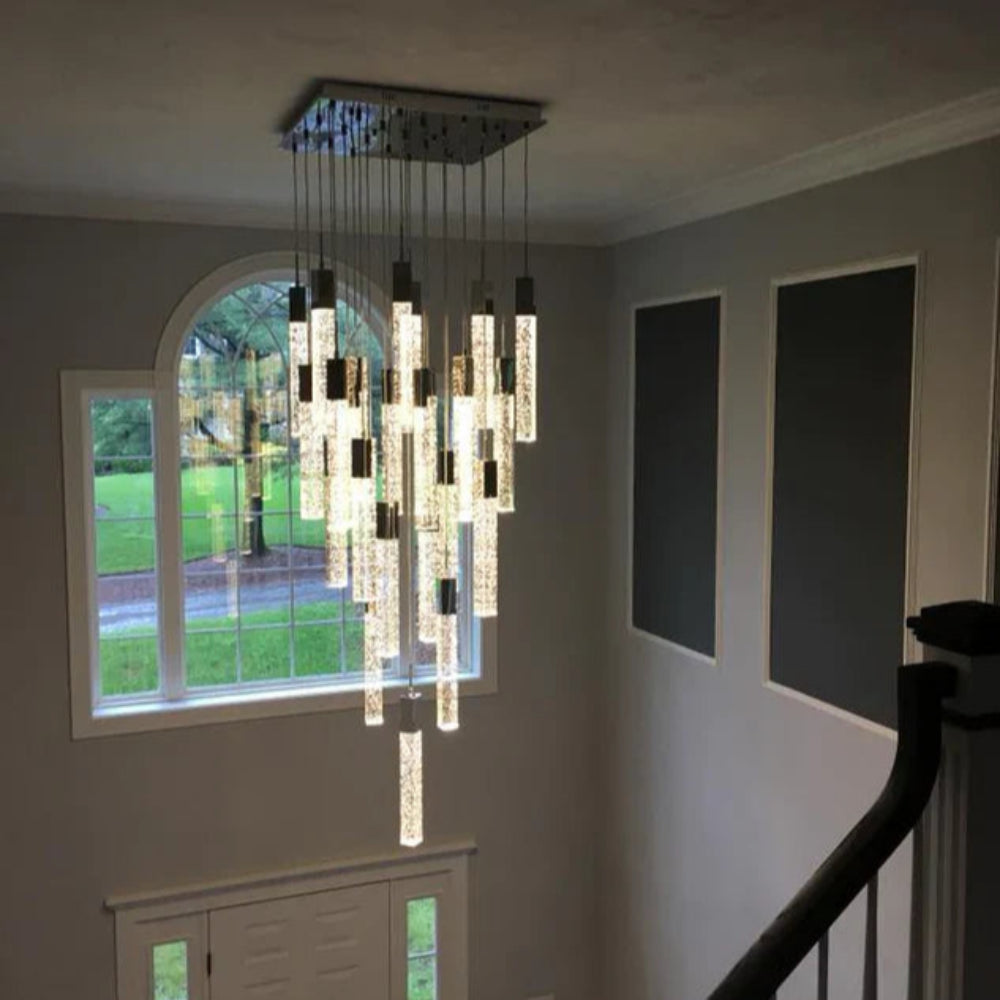 Chandelier hanging in a room with a window and staircase