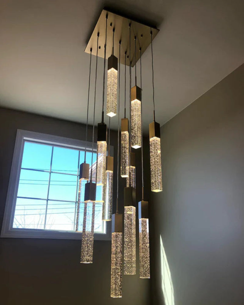Modern chandelier hanging from a ceiling with a window in the background