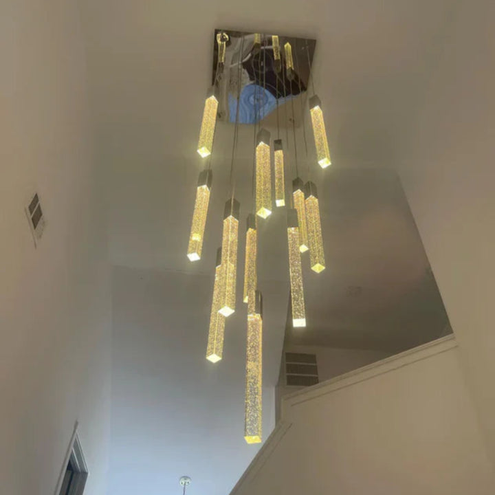 Modern chandelier hanging from a ceiling in a room with white walls.