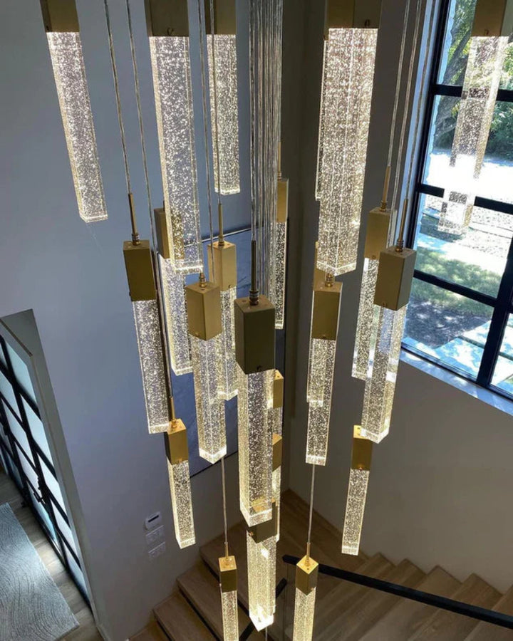 Modern chandelier with crystal-like elements hanging above a staircase.